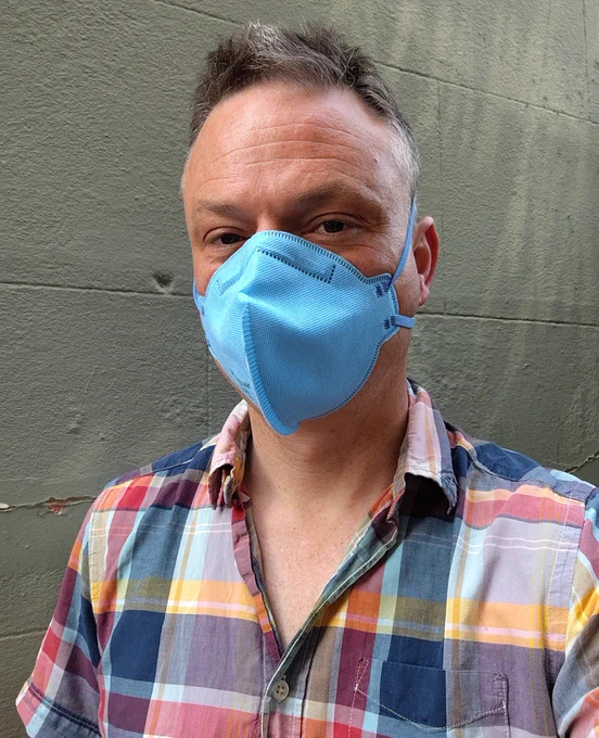 Man wearing a blue N95 mask.