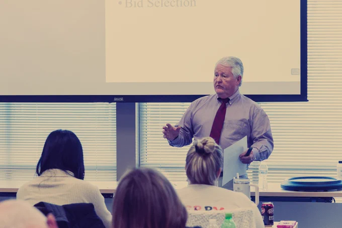 MTAS employee instructing in classroom with projector screen in background and seated people in the foreground