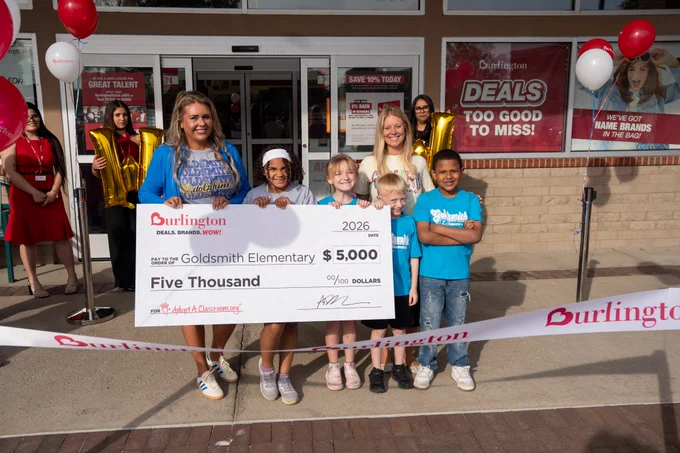 Students and adults hold a giant check for $5,000.