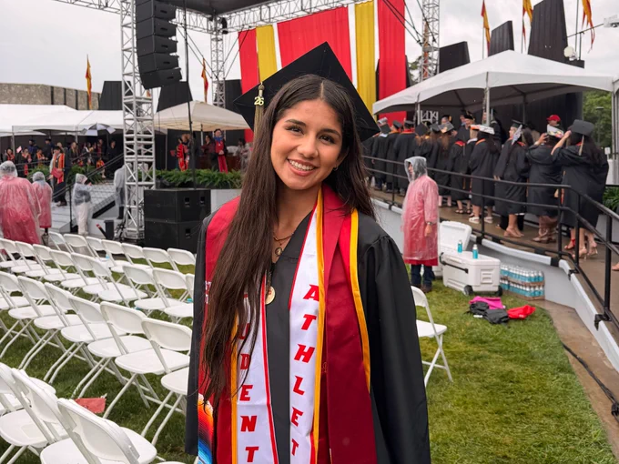 Noheli Ron smiling and posing at commencement.
