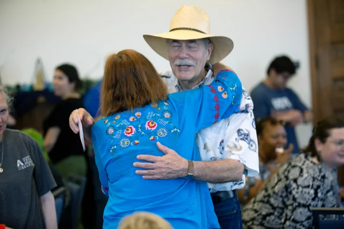Pictured is a photo of UTA Libraries staff member Bonnie Dreitner giving a person a hug at her retirement party.