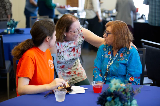 Pictured is a photo of UTA Libraries staff member Bonnie Dreitner talking with two people at her retirement party. 