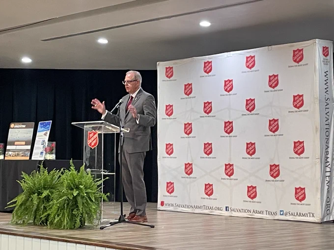 Dean Sherman standing at the podium, speaking during the Salvation Army Luncheon.