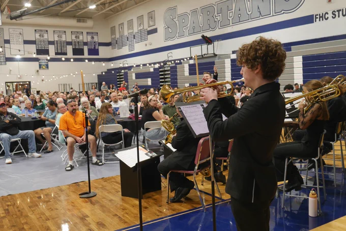 A member of the Francis Howell Central jazz band plays the trumpet during the Jazz Central Concert at FHC while the crowd looks on