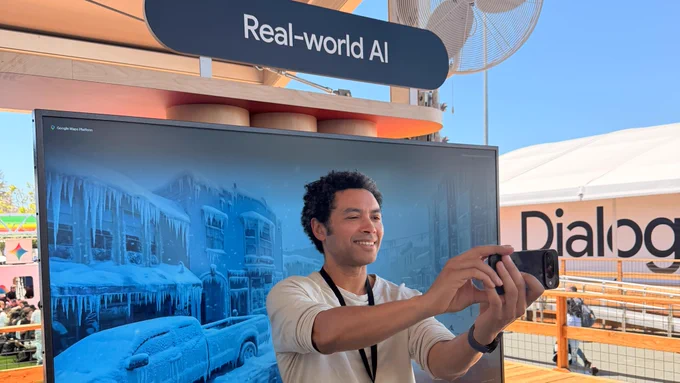 A person takes a selfie with a snowy backdrop on a screen. A sign above the screen reads "Real-world AI."