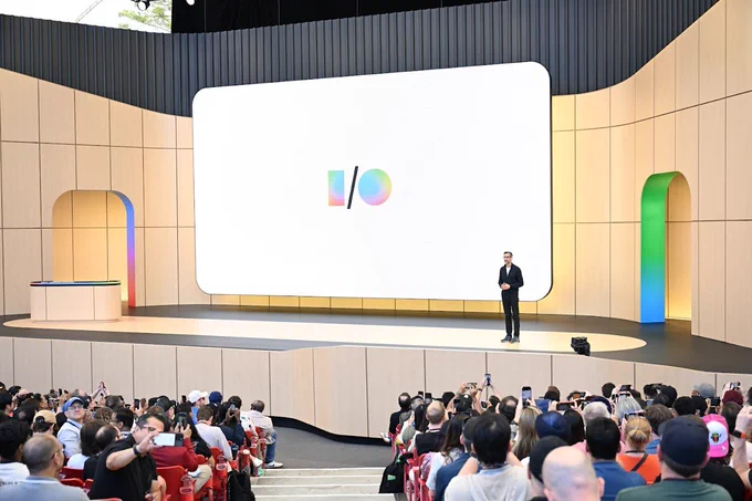 A person on a large stage with a screen showing the I/O logo addresses an audience.
