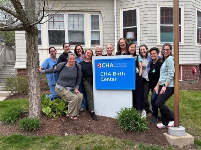12 people standing next to a sign that reads CHA Birth Center