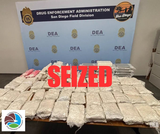 Large quantity of seized drug packages displayed on a table at DEA San Diego Field Division office.