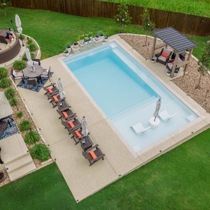 Overhead view of Ovation 30 pool in Santorini Sky with patio seating, landscaping, and backyard lounge areas.