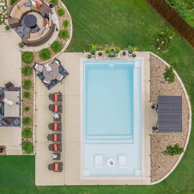 Aerial view of Ovation 30 fiberglass pool with light blue Santorini Sky water and modern patio layout.