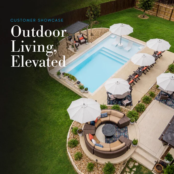 Ovation 30 fiberglass pool in Santorini Sky with open umbrellas, lounge seating, and outdoor living space.