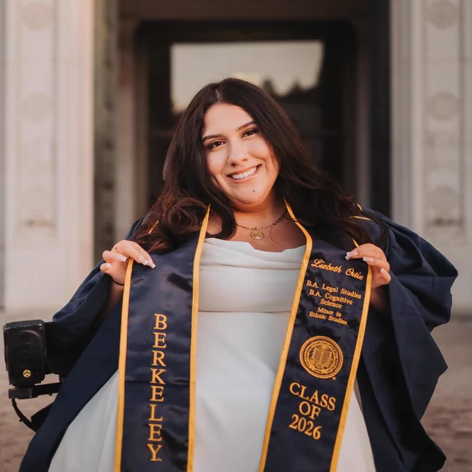 A UC Berkeley graduate poses with their graduation stole in front of Doe Library. @lizbeth__ortiz on Instagram