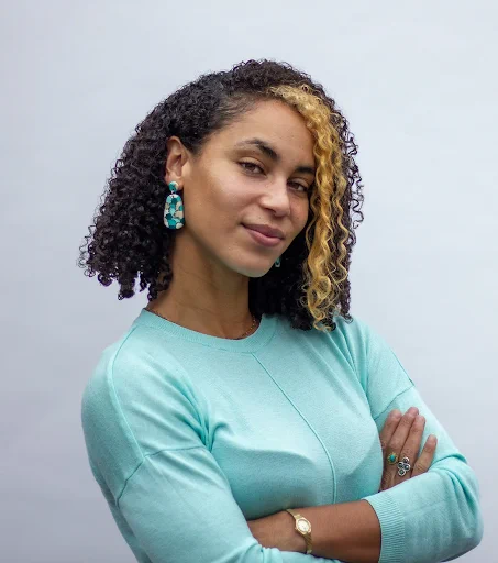 Portrait of Dr. Laura Lewis smiling with her arms crossed.