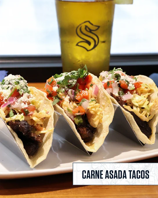 Photo of carne asada tacos with a beverage at a restaurant. 