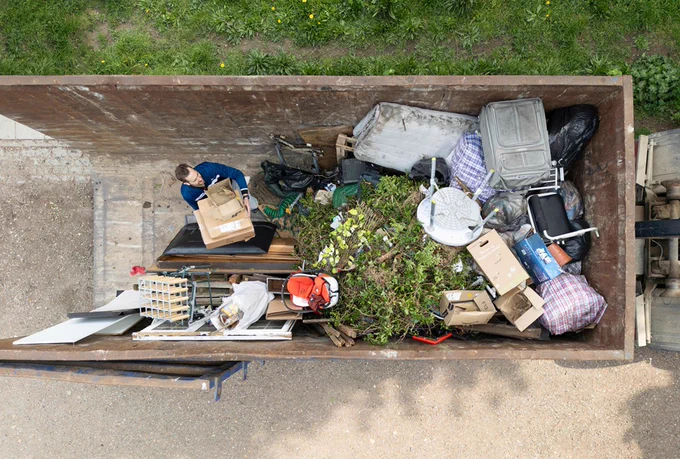Aerial view of someone placing bulky items in a mega skip
