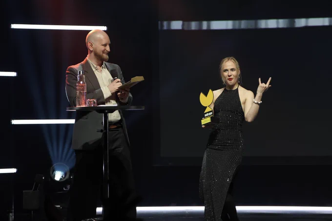 Two people on stage celebrating an awards ceremony