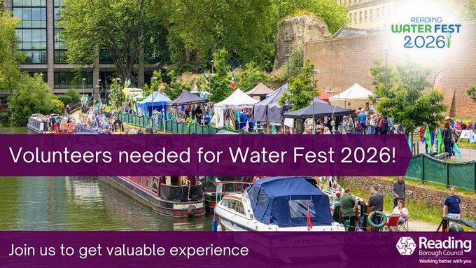 A busy riverside festival scene with colourful boats moored along the water and crowds walking among tents and stalls set up on the grass. Trees and old brick walls surround the area. Overlaid text reads “Volunteers needed for Water Fest 2026!” and “Join us to get valuable experience.” The Reading Borough Council and Water Fest 2026 logos appear in the corners.