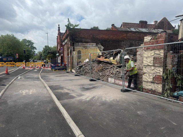 View down Talbot Road showing the secure fence around the demolished building. There is no rubble on the pavement or the road.