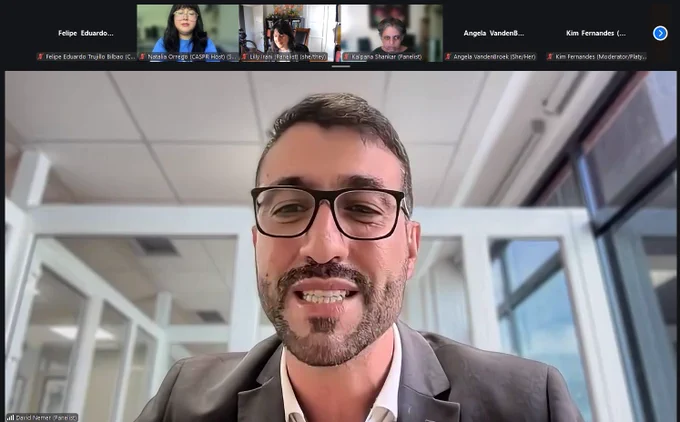 A Zoom meeting screenshot displaying David Nemer in the main speaker view. He is a man with a beard and dark-rimmed glasses, wearing a grey suit jacket and a white shirt, and he appears to be speaking. The background behind him shows a bright office environment with glass partitions. Along the top of the screen is a row of smaller video thumbnails showing other participants, including Natalia Orrego, Lilly Irani, and Kalpana Shankar, alongside nameplates for participants without video enabled.