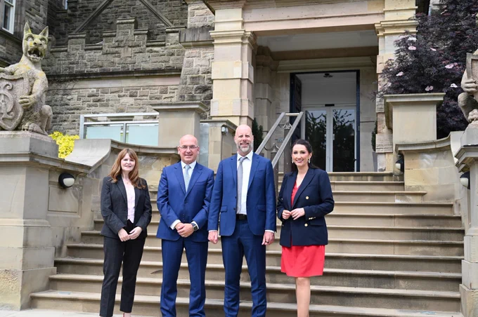 Image of four people standing outside Stormont Castle – left to right, Economy Minister Dr Caoimhe Archibald, Fernando Vicario, CEO of Merrill Lynch International and head of Bank of America NA London Branch, Tom Scrivener, Chief Operations Executive for Bank of America, deputy First Minister Emma Little-Pengelly.