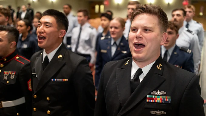 Sidney Anop ’26, right, shown during an ROTC awards ceremony in April, started his Navy career as an enlisted information systems technician. Now an ensign, the ILR School graduate is the first member of Cornell Navy ROTC to commission through the Seaman to Admiral-21 program.