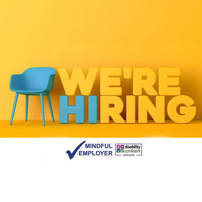 Blue chair positioned beside large 3D text reading “WE’RE HIRING” on a bright yellow background. Below, the Mindful Employer and Disability Confident Employer logos are displayed.
