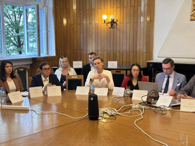 Uczestnicy podczas wydarzenia, rozmawiają siedząc przy okrągłym stole. Na zdjęciu widoczna między innymi Sekretarz Stanu Adriana Porowska.