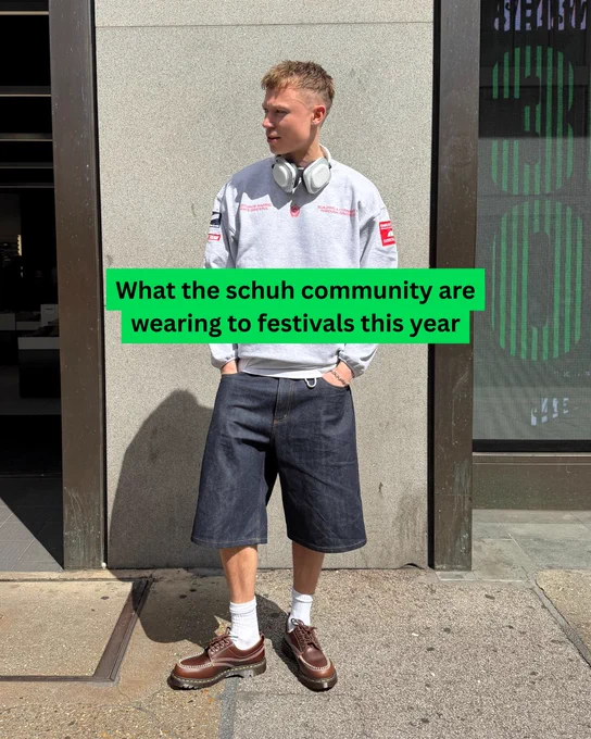 An image of a person wearing a pair of brown Dr Martens Lowell Moc Toe shoes whilst standing in front of a concrete wall with text overlaying the image saying "what the schuh community are wearing to festivals this year".