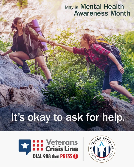 Two women with hiking gear climb up rocks with one holding the other's hand to help her. Text says 'May is Mental Health Awareness Month. It's okay to ask for help.' With the Veterans Crisis Line and Michigan Veterans Affairs Agency logos.