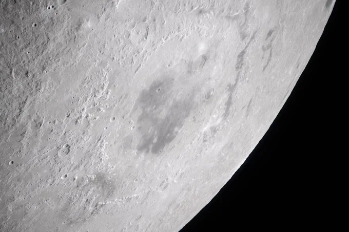 During the lunar flyby observation period, the Artemis II crew captured a detailed image of the Orientale basin, a 600-mile-wide impact crater marked by a dark patch of ancient lava that erupted through the Moon’s crust billions of years ago. Credit: NASA