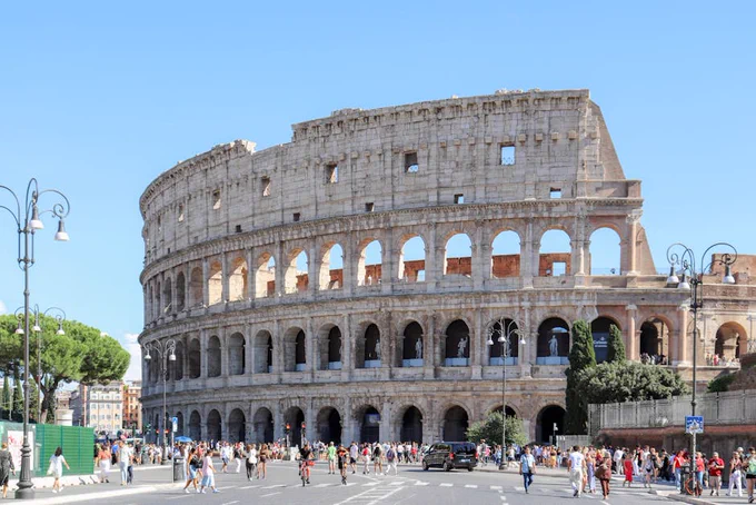 The Colosseum in Rome, Italy, bustling with tourists on a sunny day.