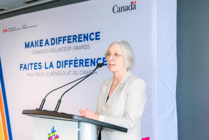 Minister Hajdu speaking at the podium. 