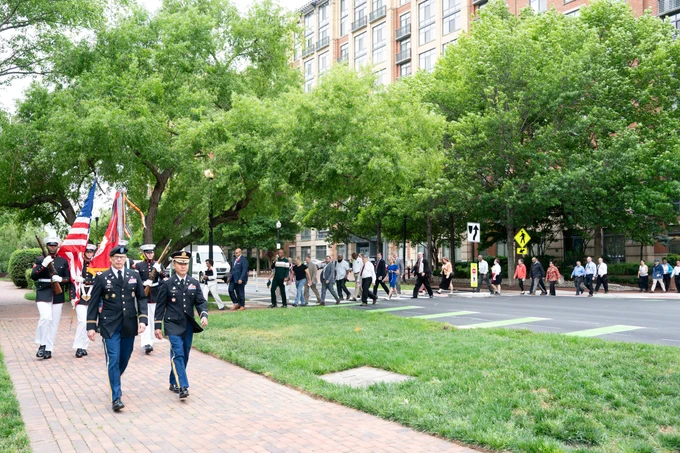 Photo of a large group of people observing the Walk of Remembrance, walking towards the National Cemetery in Alexandria, VA.