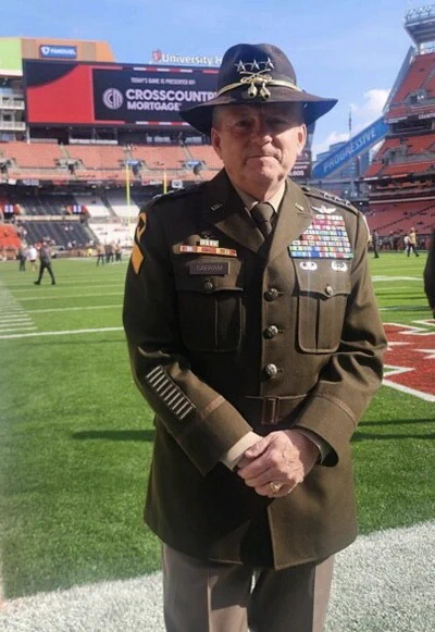 US military person with medals and honors on his uniform being recognized at a sporting event