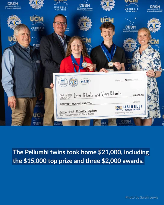 Five people stand in front of a blue backdrop with logos, smiling and holding a large check for $15,000 addressed to Drini and Vjosa Pellumbi. Two of them, a young girl in a red sweater and a young man in a black shirt, wear medals and hold certificates. Text below reads, "The Pellumbi twins took home $21,000, including the $15,000 top prize and three $2,000 awards."