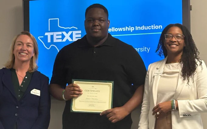 A person stands in the center holding a certificate, flanked by two others. A "TEXE Fellowship Induction" sign is displayed on a screen in the background. Everyone is smiling and dressed in semi-formal attire.