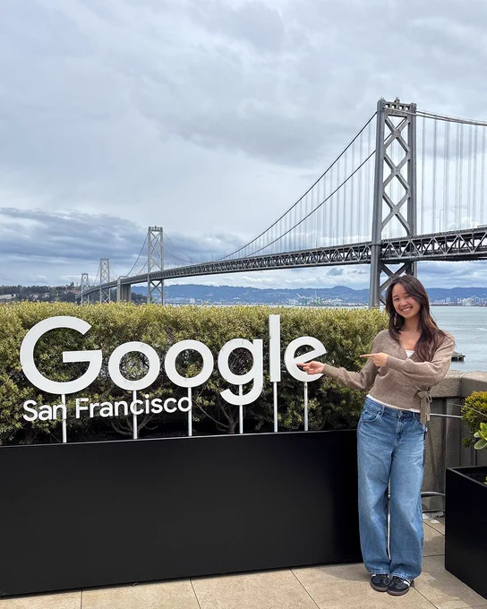 Kaylee posing in front of the outdoor Google San Francisco sign, with a view of the Golden Gate Bridge behind her.