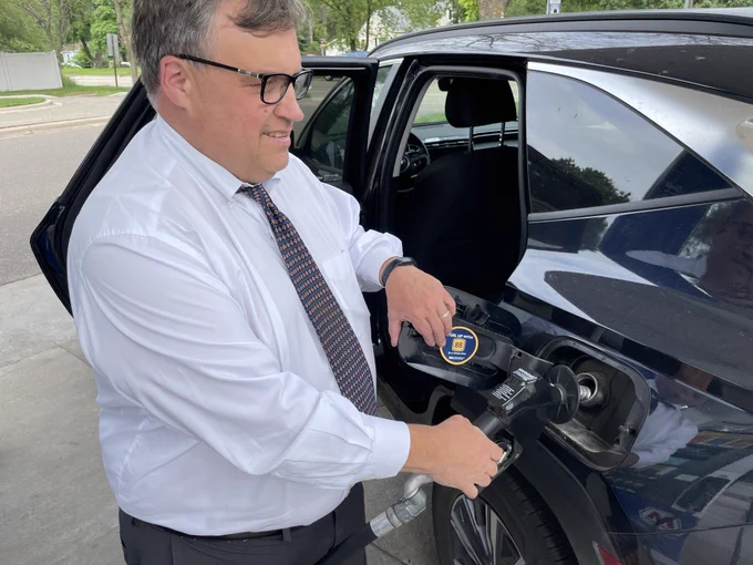 Minnesota Agriculture Commissioner, Thom Petersen, filling up a car with unleaded 88 at a fuel station.