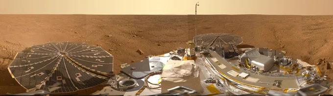 360 view from the Mars Phoenix lander: solar panel and science gear on its deck, with reddish rocky Martian all the way to the horizon