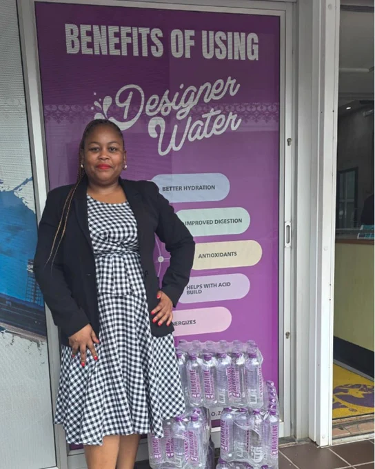 Picture of Nobuhle Khumalo recent Waterpreneur to the team in Morningside, KZN. She is standing outside the Master Distributor's warehouse with her Designer Water pH10.