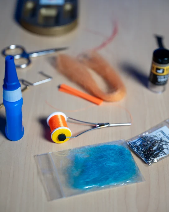 Orange and blue fly tying supplies for making a lure. 