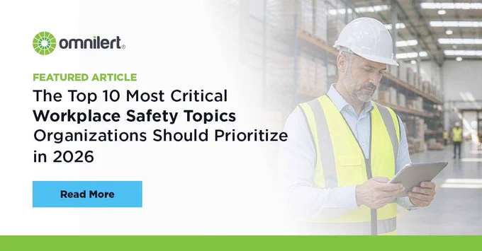 A graphic. The left half is white and fades into an image of a a worker in a warehouse holding a tablet. On the white half, in small green text it says "Featured Article," and below it, in larger black font "The Top 10 Most Critical Workplace Safety Topics Organizations Should Prioritize in 2026." Above the text is the Omnilert logo, and below it is a non-clickable button that says "Read More."