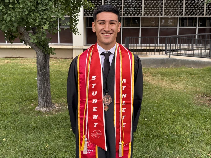 A Stan State student stands with Chi Alpha medal and Student Athlete stoll.