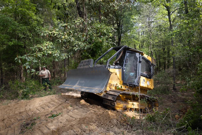 Alabama Forestry Commission wildland firefighter Jason Berry teaches NASA Wildland Fires Technology Program Manager Teresa Kauffman how to drive a fire bulldozer during a stakeholder event April 23-24 in Andalusia, Alabama. NASA FireSense scientists have been working with the AFC to integrate thermal sensors onto these dozers, which notify the dozer operator if the radiant heat from a nearby fire reaches a dangerous threshold. NASA/Milan Loiacono