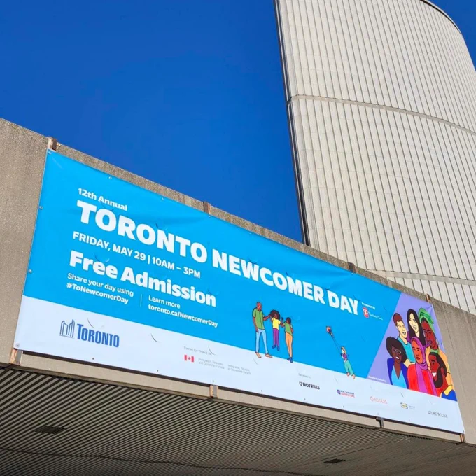 Banner for the 12th Annual Toronto Newcomer Day on May 29, offering free admission from 10 AM to 3 PM with diverse illustrated people.