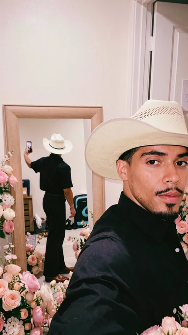 Matthew J. Sánchez, Perfumer & Founder of MATTEO PARFUMS, an award-winning global fine fragrance brand backed by L’Oréal and named to the 2026 Forbes 30 Under 30 list, wearing Western apparel with a cream cowboy hat, black pearl snap shirt, black denim bootcut jeans, and red leather pointed cowboy boots