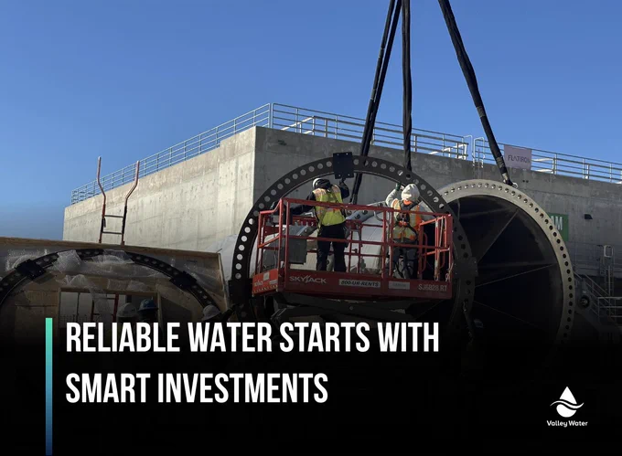 Workers are on a lift installing a large pipe section at a construction site. There is a concrete structure in the background. Text on the image reads, "Reliable water starts with smart investments." The logo in the corner indicates "Valley Water.