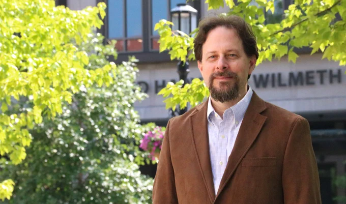 Michael Fosmire in a brown suit jacket in front of Wilmeth Active Learning Center with trees in the background
