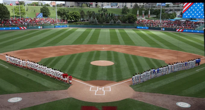 Teams from Nebraska (left) and South Dakota State (right) line up on the foul lines for the national anthem prior to first pitch of the NCAA Division I Baseball Championship at Hawks Field in Lincoln, Nebraska, on May 29, 2026.