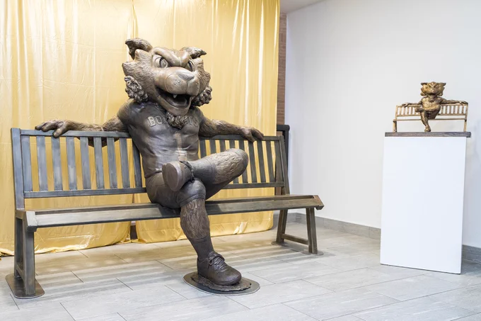 Metal bench with life-size Boko the Bobcat statue sitting on the bench